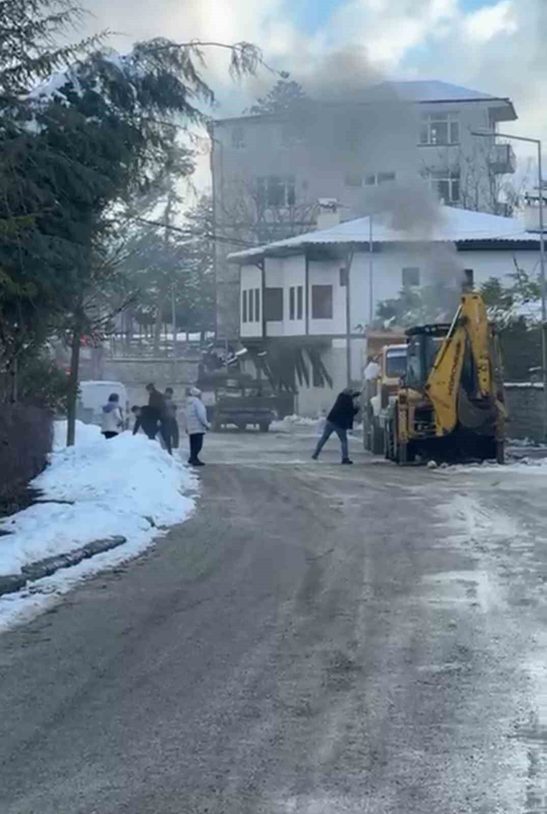 İş makinesinde çıkan yangını karla söndürmeye çalıştılar
